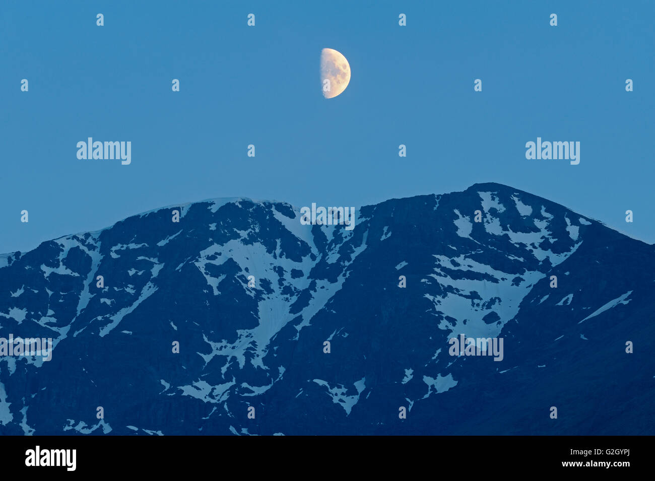 Half moon rising above mountain Stewart Cassiar Highway British