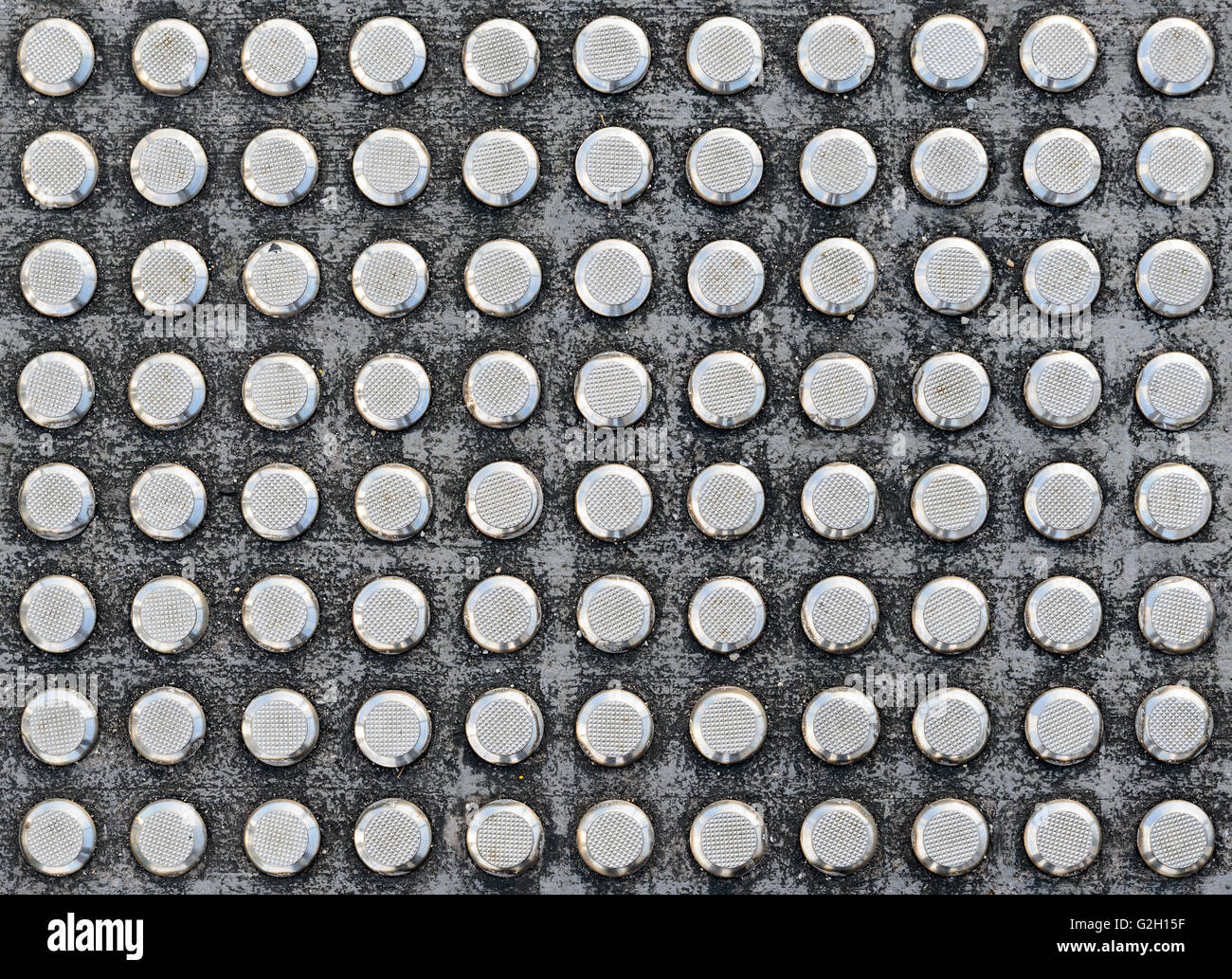 Studs tactile paving textured surface for blind or visually impaired people at a pedestrian crossing Stock Photo