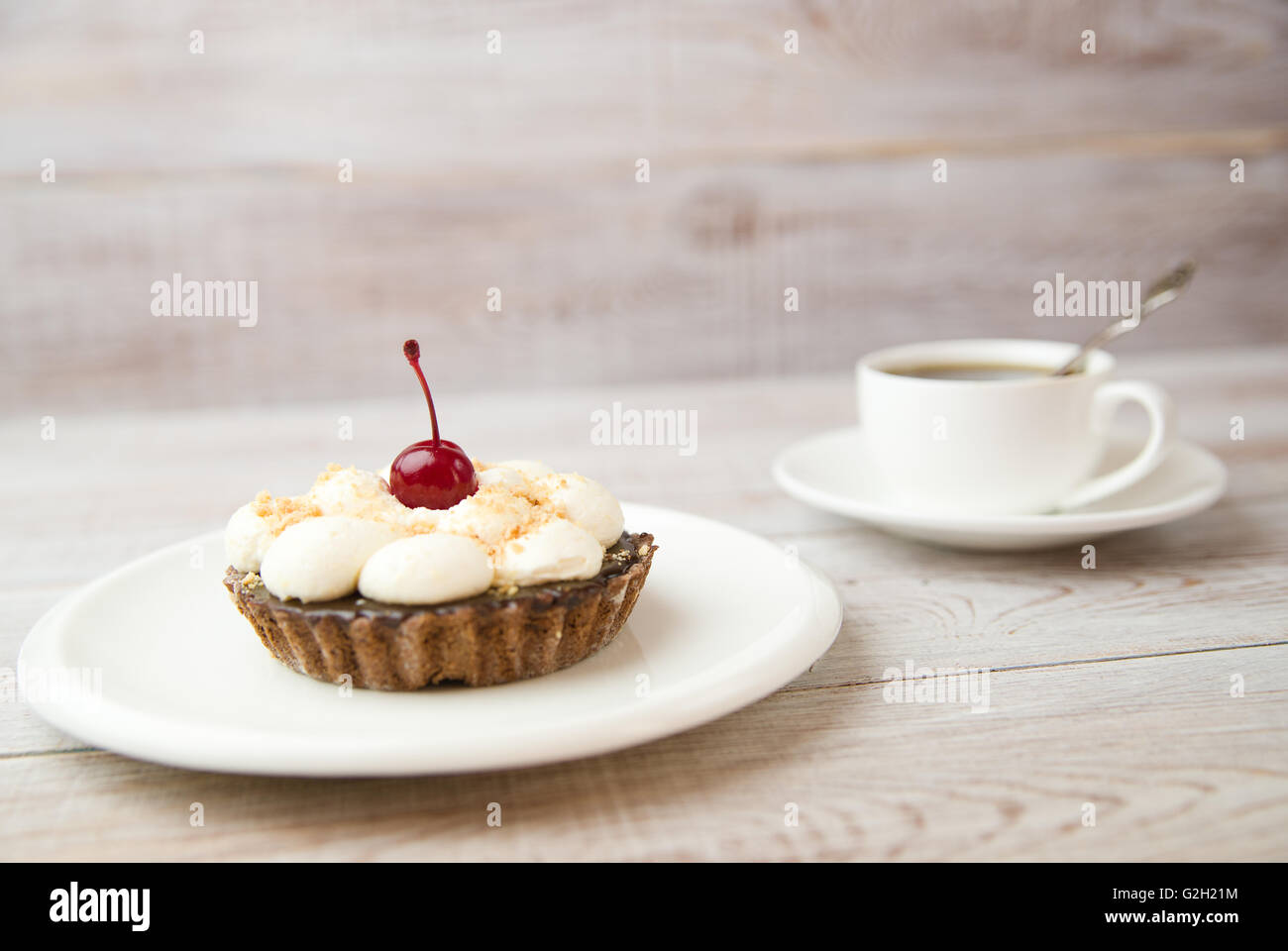 Cake with cream and white cup on the table Stock Photo
