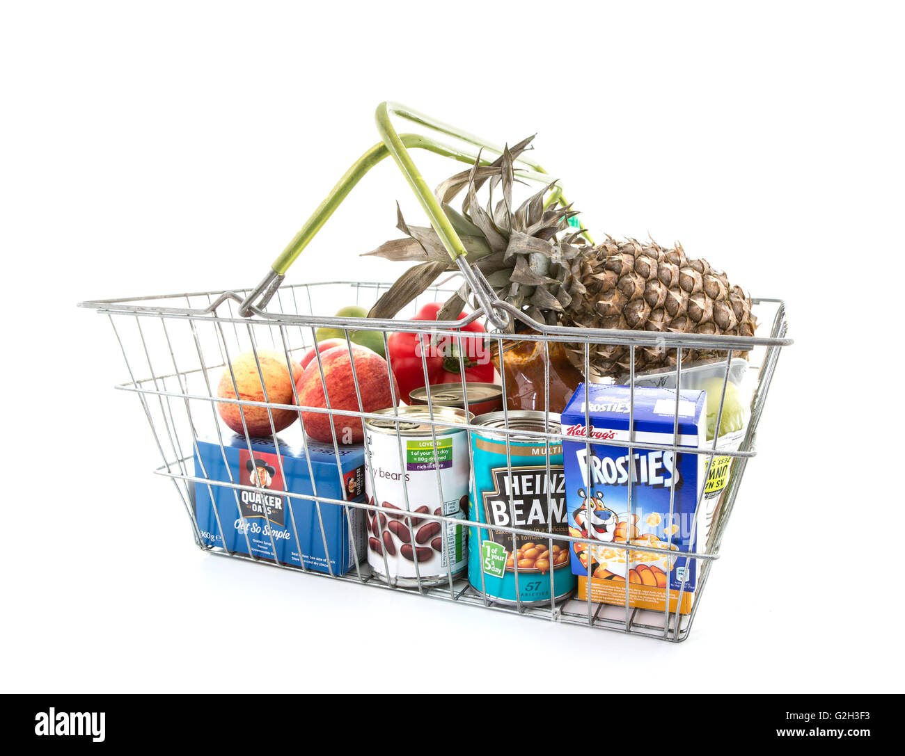 Selection of Vegetables and Groceries in a wire Shopping Basket on a white background Stock Photo