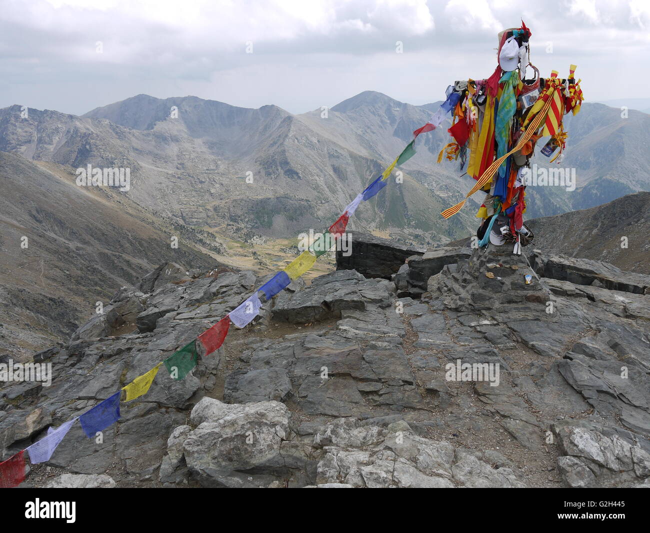 On the top of Canigou Montain, in french Catalogna, poeple use to mark their passage with national flags on a cross Stock Photo