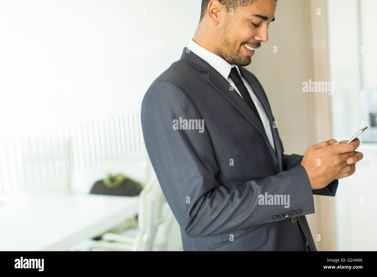 Young black man with mobile phone in the office Stock Photo