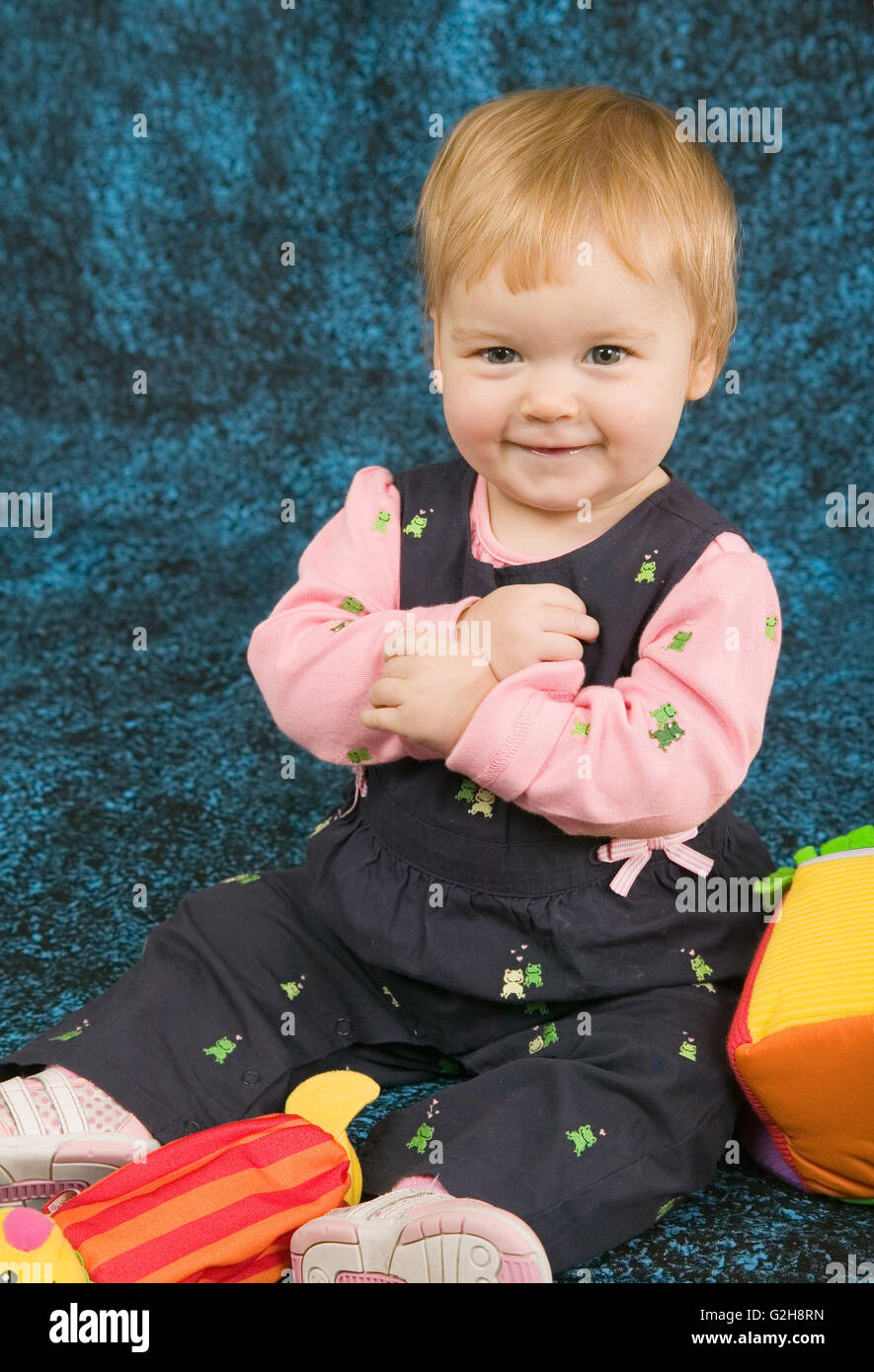 Cute 10 month old girl surrounded by her toys Stock Photo Alamy