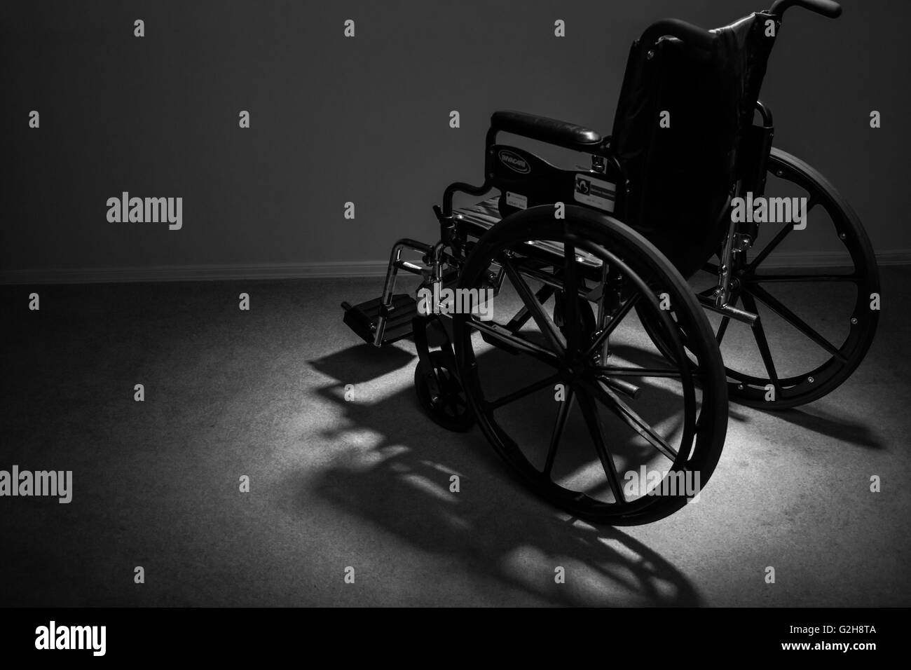 Wheelchair facing away, reinforcing the feeling of isolation and depression that can be associated with personal injury Stock Photo