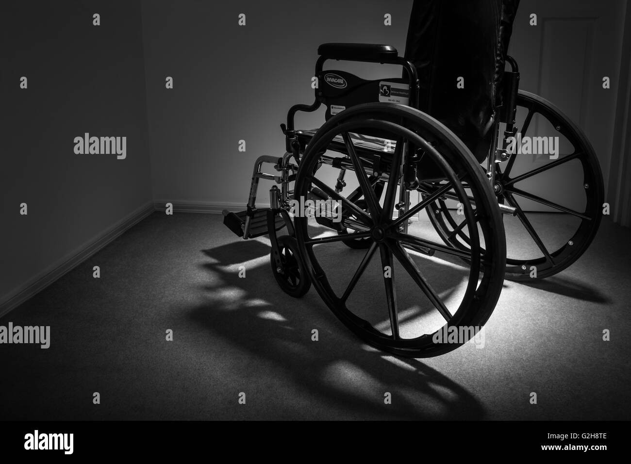 Wheelchair facing away, reinforcing the feeling of isolation and depression that can be associated with personal injury Stock Photo