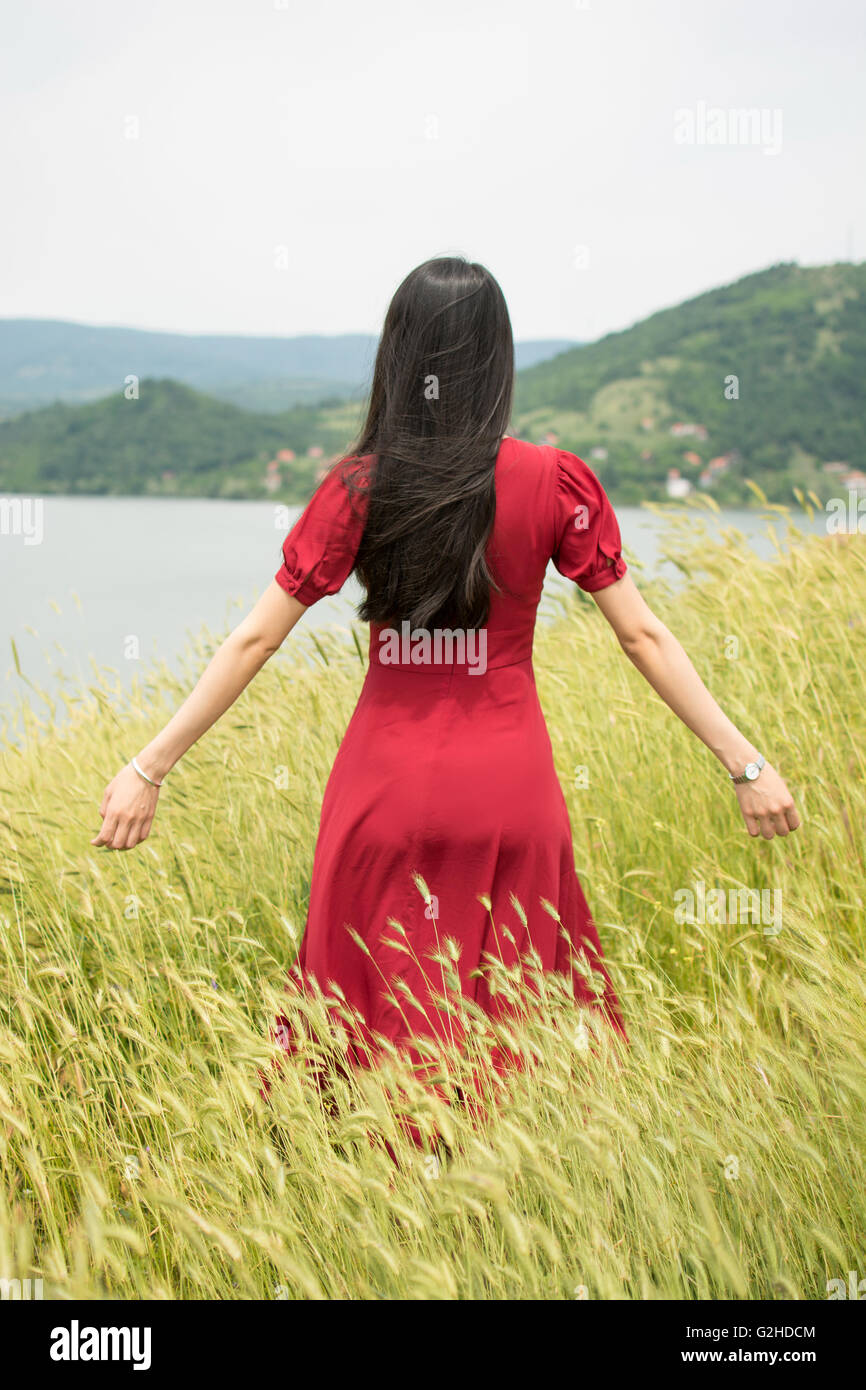 Fashionable girl in a wheat field wearing red dress Stock Photo - Alamy