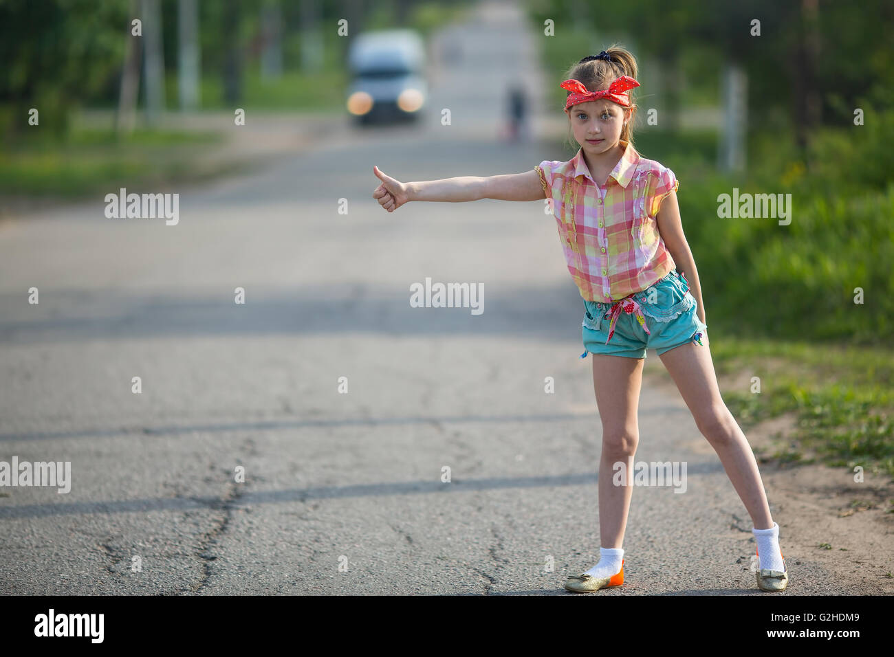 Little girl hitchhiking along a road Stock Photo Alamy