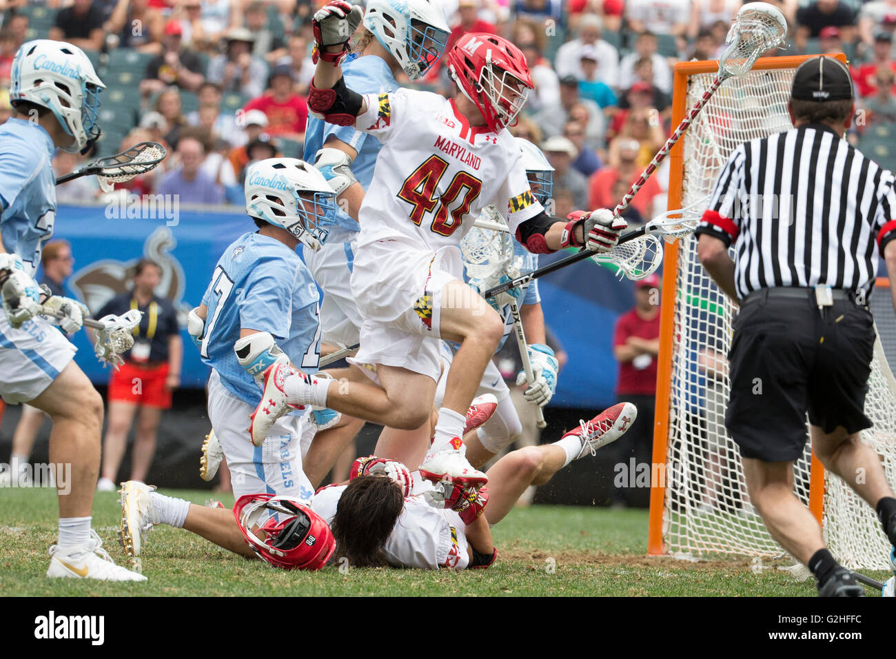Philadelphia, Pennsylvania, USA. 30th May, 2016. Maryland Terrapins midfielder Connor Kelly (40) leaps over attack Colin Heacock (2), who was knocked to the ground and lost his helmet, during the NCAA Division I championship lacrosse match between the North Carolina Tar Heels and the Maryland Terrapins at Lincoln Financial Field in Philadelphia, Pennsylvania. Christopher Szagola/CSM/Alamy Live News Stock Photo
