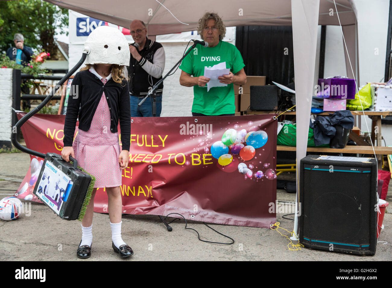 Harmondsworth, UK. 30th May, 2016. A young local resident demonstrates a 70th birthday gift to Heathrow airport at a gathering by campaigners against Heathrow expansion in Harmondsworth village. Much of Harmondsworth would be flattened should plans for a 3rd runway be approved. Credit:  Mark Kerrison/Alamy Live News Stock Photo