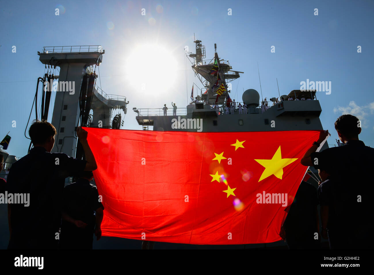 Dar Es Salaam, Tanzania. 30th May, 2016. Local Chinese holding Chinese national flag welcome?Chinese naval comprehensive supply ship?Taihu at Dar es Salaam, Tanzania, on May 30, 2016. Three Chinese navy ships on Monday docked at Tanzania's Dar es Salaam Port for a four-day visit, aimed at sharing experience with their Tanzanian counterparts in how to curb piracy in the Indian Ocean. © Zhai Jianlan/Xinhua/Alamy Live News Stock Photo