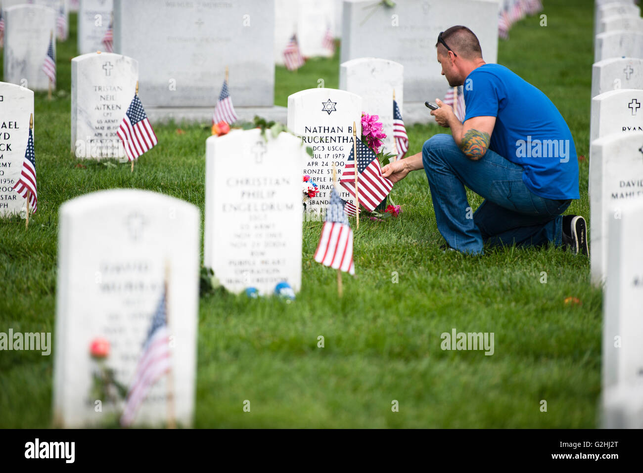 Arlington National Cemetery, Virginia, USA. 30th May, 2016. U.S. Coast Guard Petty Officer First Class Sam Allen visits the grave of U.S. Coast Guard Petty Officer 3rd Class Nathan B. Bruckenthal on Memorial Day at Arlington National Cemetery May 30, 2016 in Arlington, Virginia. Bruckenthal was the first member of the Coast Guard killed in action since the Vietnam War. Credit:  Planetpix/Alamy Live News Stock Photo