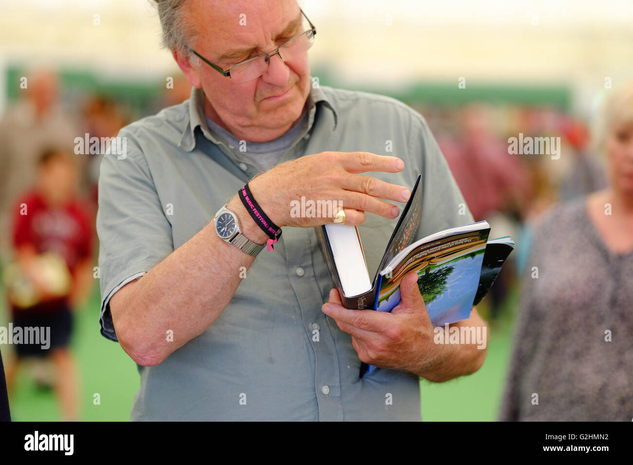 Hay Festival, Wales, UK - May 2016 -  A visitor to the Hay Festival juggles books and his Festival program in the Festival bookshop. Stock Photo