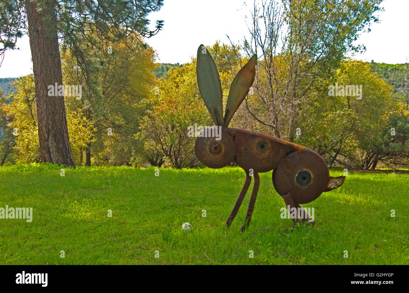 Hand-crafted metal rabbit, an artful decoration on the lawn for an Easter egg hunt Stock Photo