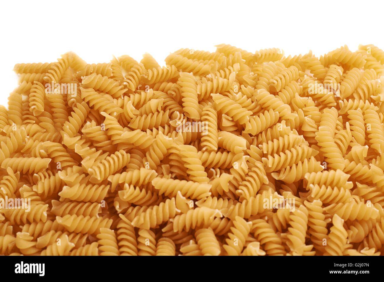 Pile of dry rotini pasta over isolated white background Stock Photo Alamy