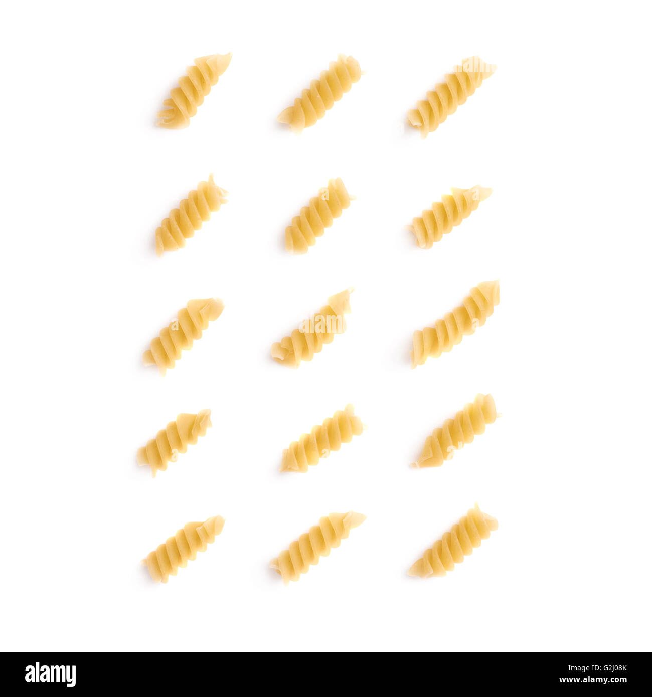 Single pieces of dry rotini pasta over isolated white background Stock