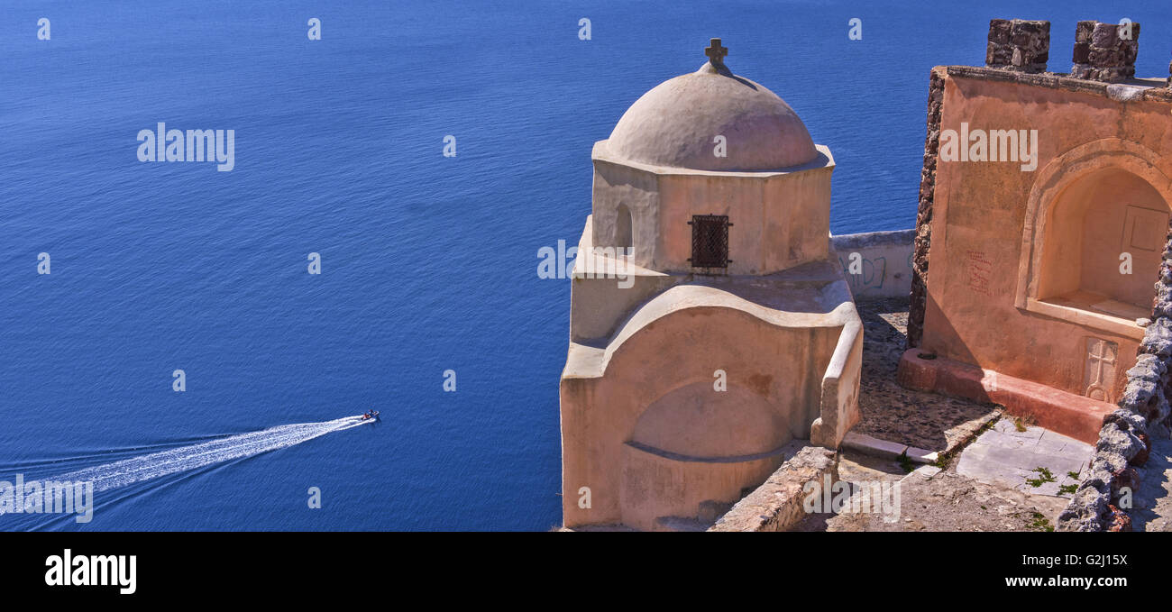 The church of Agia Aikatetini overlooking the Aegean on the rocky cliff of Oia resort in Santorini island, Cyclades, Greece Stock Photo