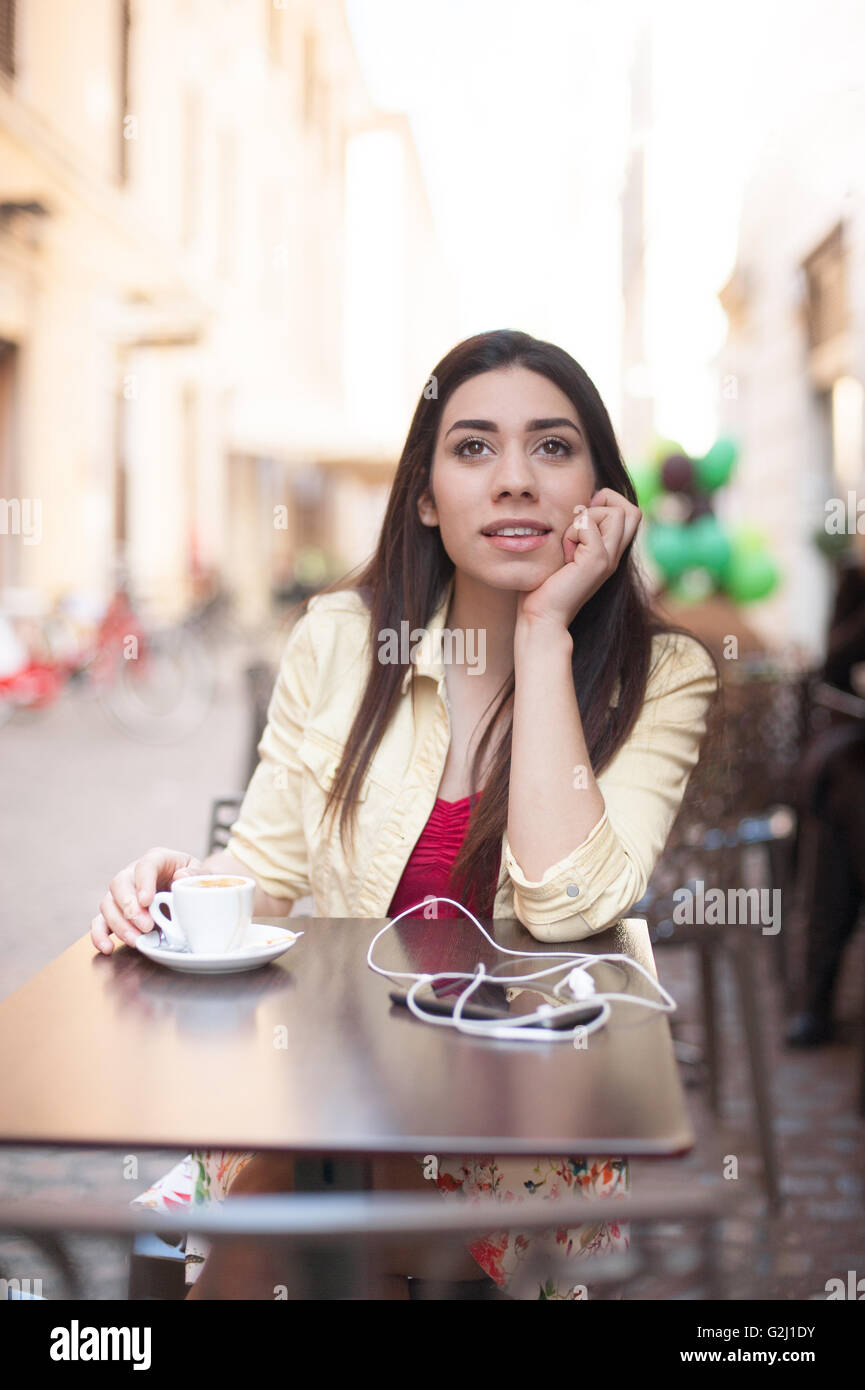Young beautiful woman sitting in coffee bar relaxing during a break Stock Photo