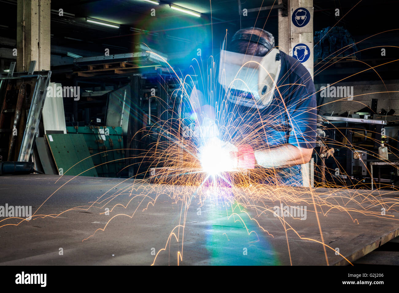 Worker welding in steel with bright light and sparks Stock