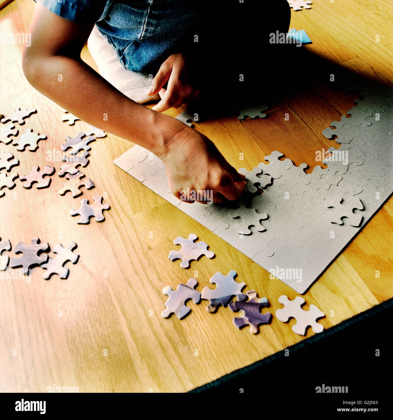 Child Putting Jigsaw Puzzle Together Stock Photo