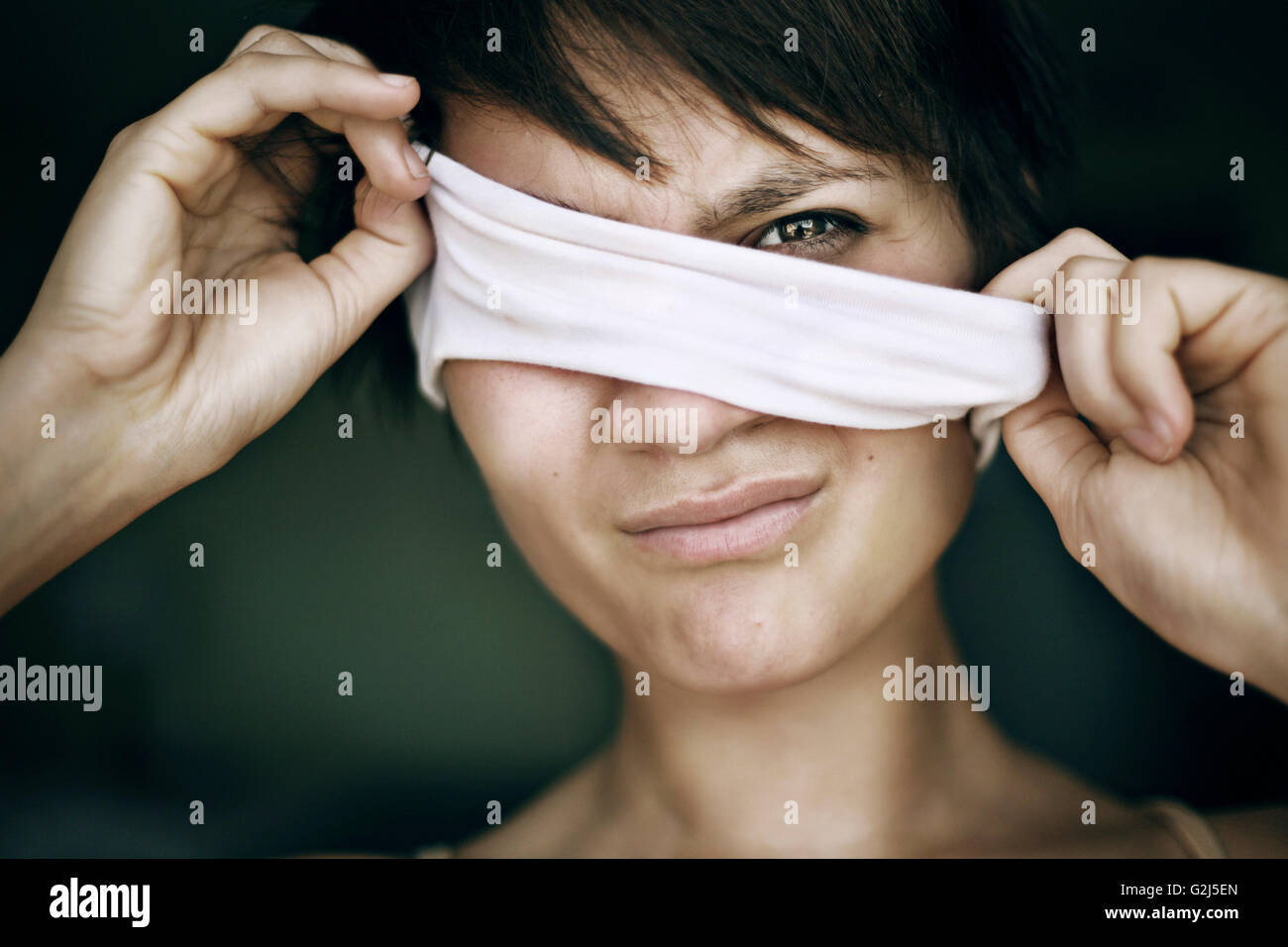 Woman Pulling Blindfold from Eyes Stock Photo
