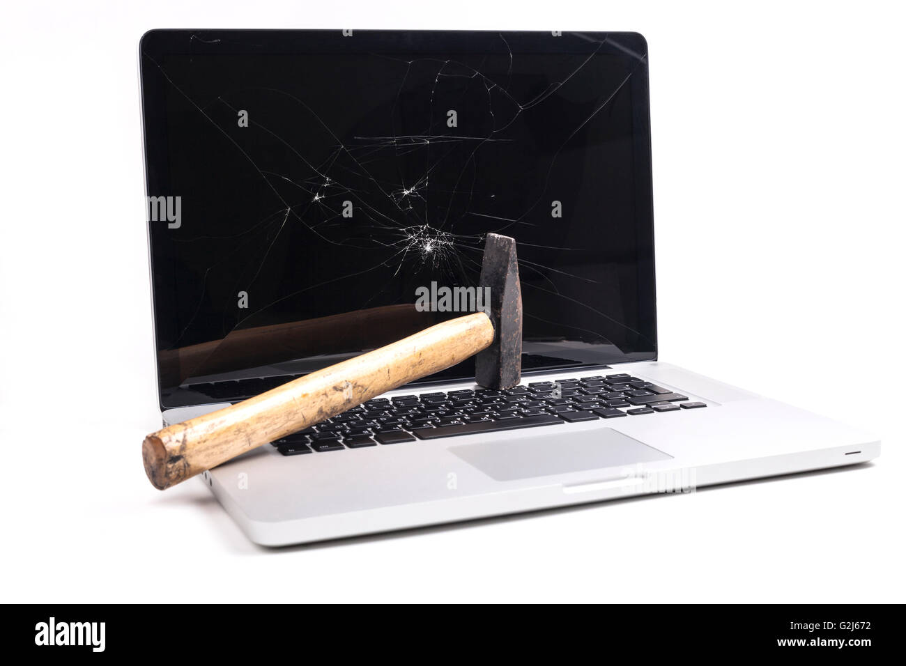 Broken laptop with smashed screen and a hammer isolated on white background Stock Photo