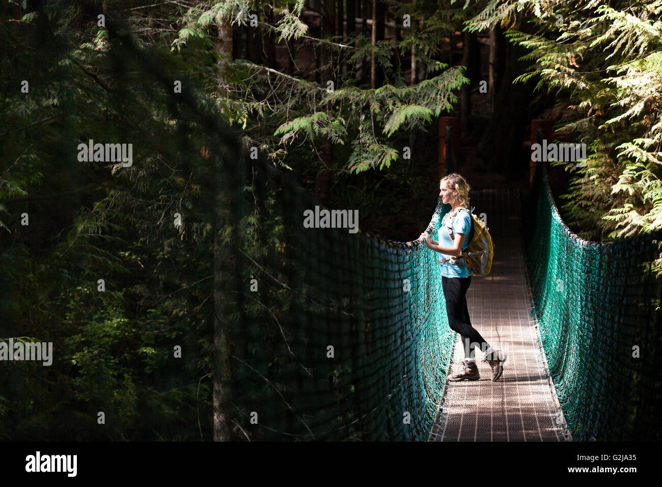 Young woman hiker on suspension bridge between China Beach and Mystic