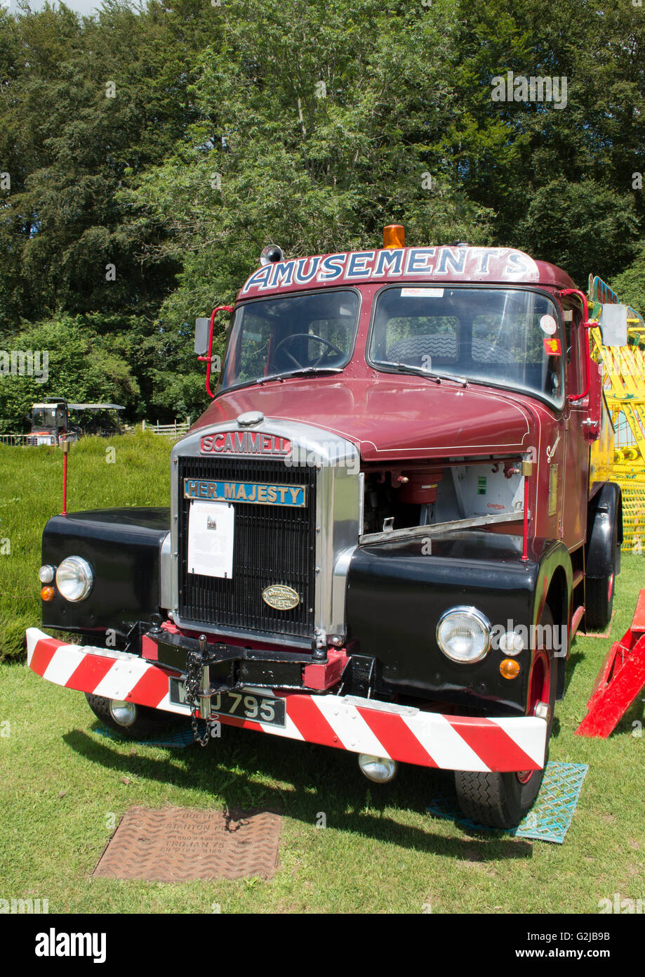Front view of an old vintage red and black Scammell Heavy Haulage Truck on grass with trees in background Stock Photo