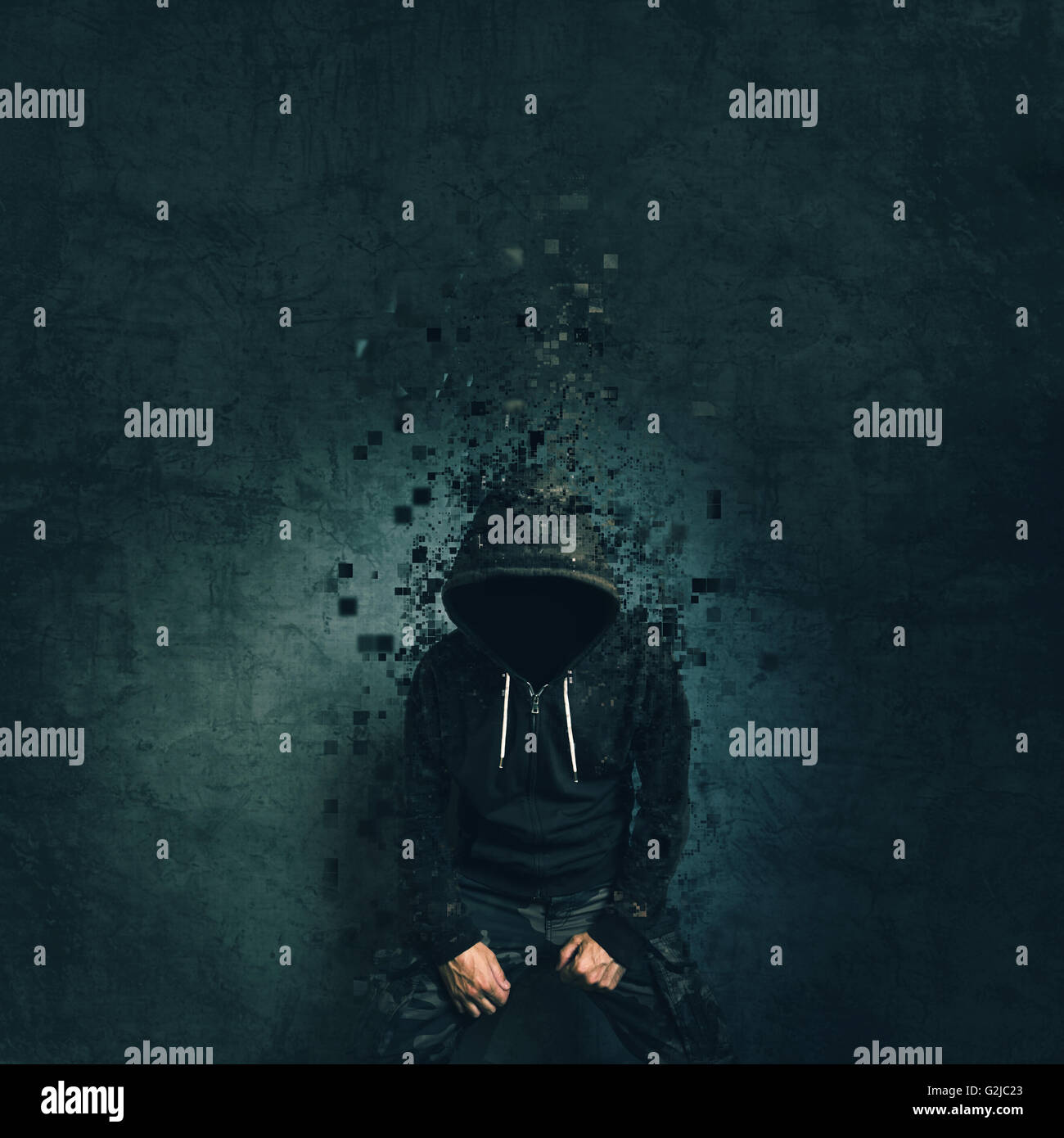 Spooky evil criminal person with hooded jacket dissolving in front of concrete wall. Stock Photo