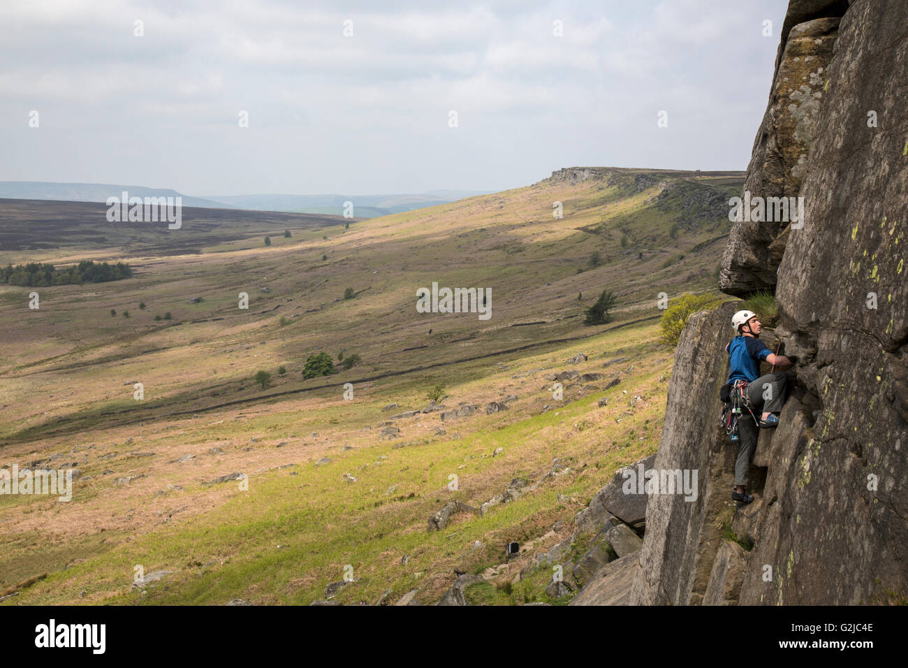Climber on cliffs of Stanage Plantation in the Peak District, Derbyshire, England. Stock Photo