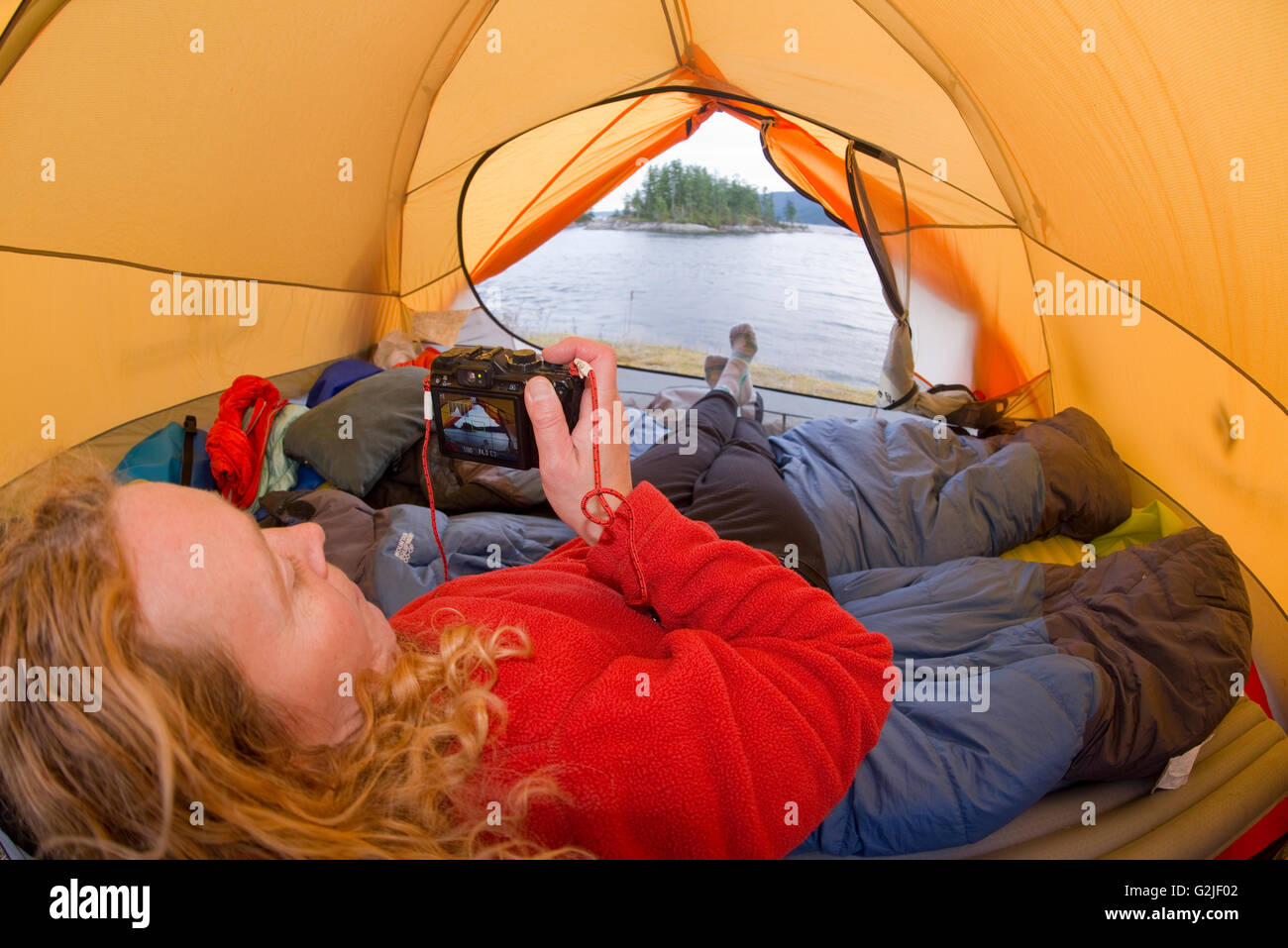 Woman in tent, camping at Kunechin Point, Sechelt Inlet. Gibsons, Sunshine Coast, British Columbia, Canada Stock Photo