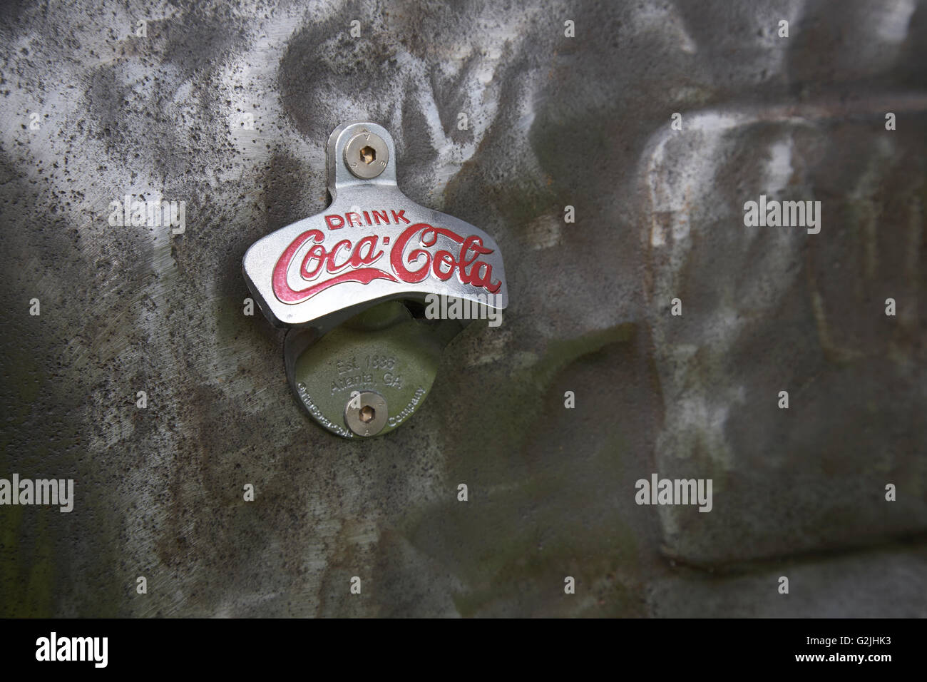 Old Coca Cola bottle top opener on beaten metal Stock Photo