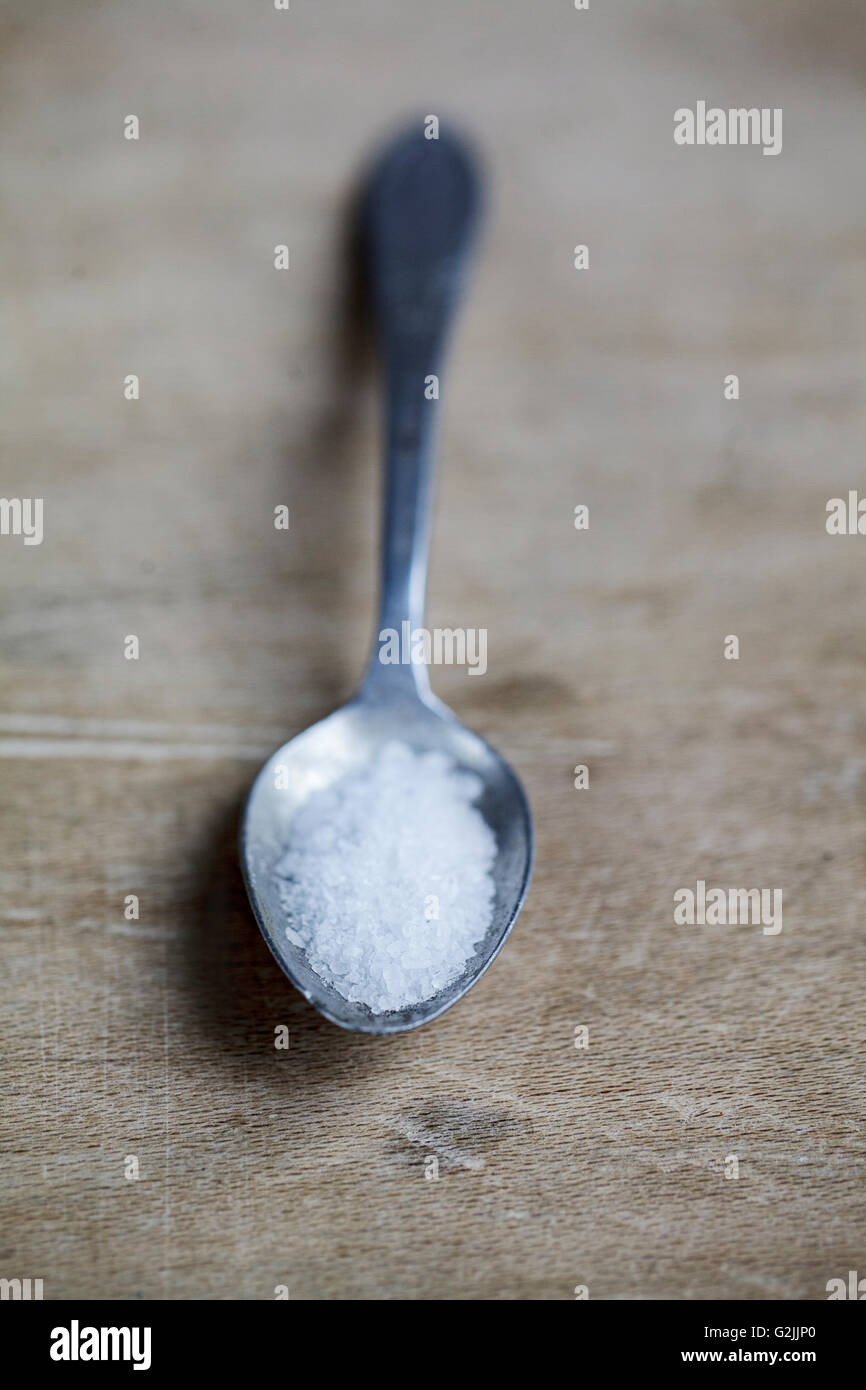 Spoon with coarse sea salt ready to be used in cooking Stock Photo Alamy