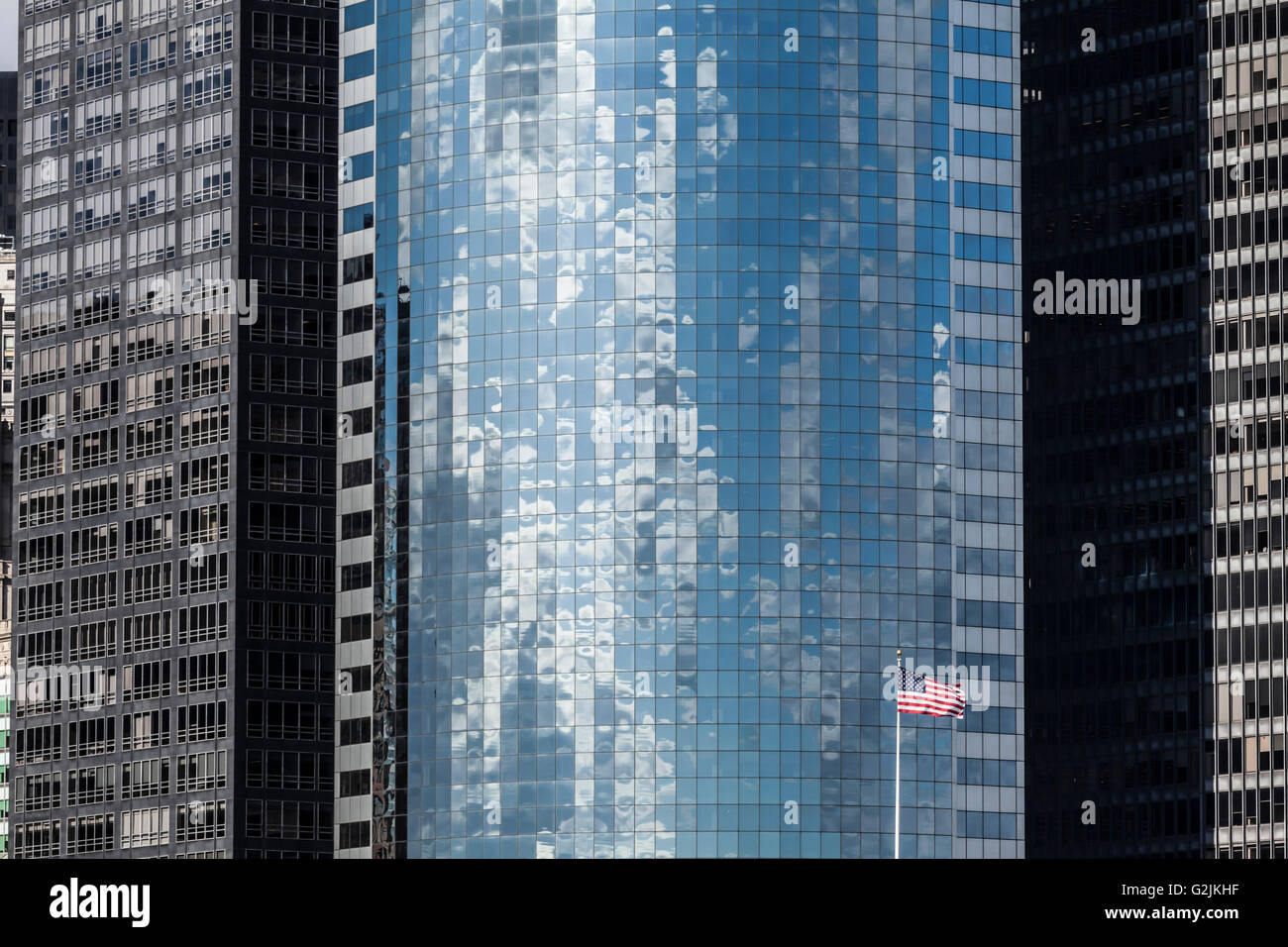 Modern skyscraper background and US flag in Manhattan, New York City. Stock Photo