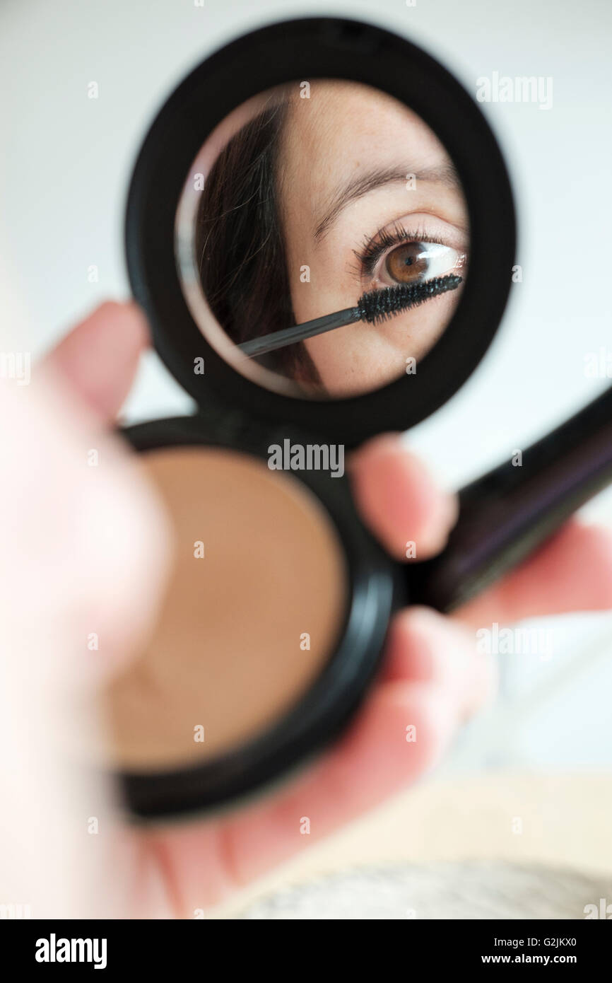 Woman applying make-up Stock Photo