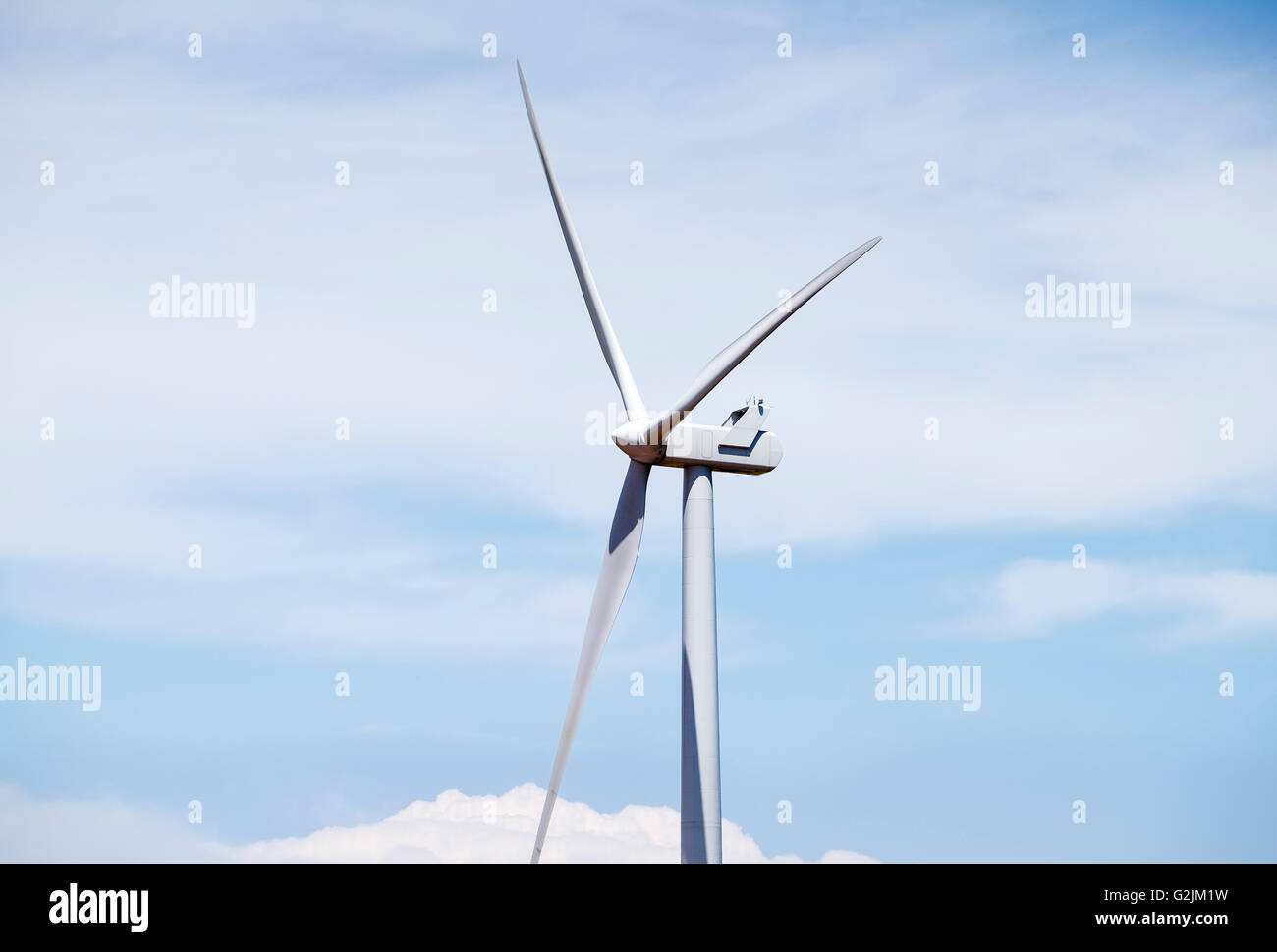 Close up view of a wind turbine against a blue and cloudy sky in ...