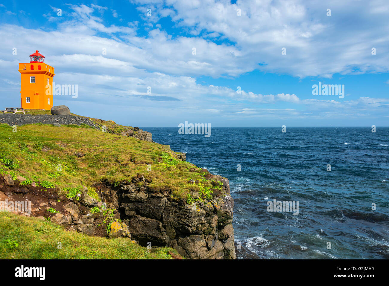 Orange lighthouse at the cost of Grimsey island nearby Iceland, summer