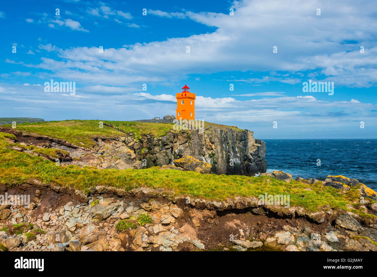 Orange lighthouse at the cost of Grimsey island nearby Iceland, summer