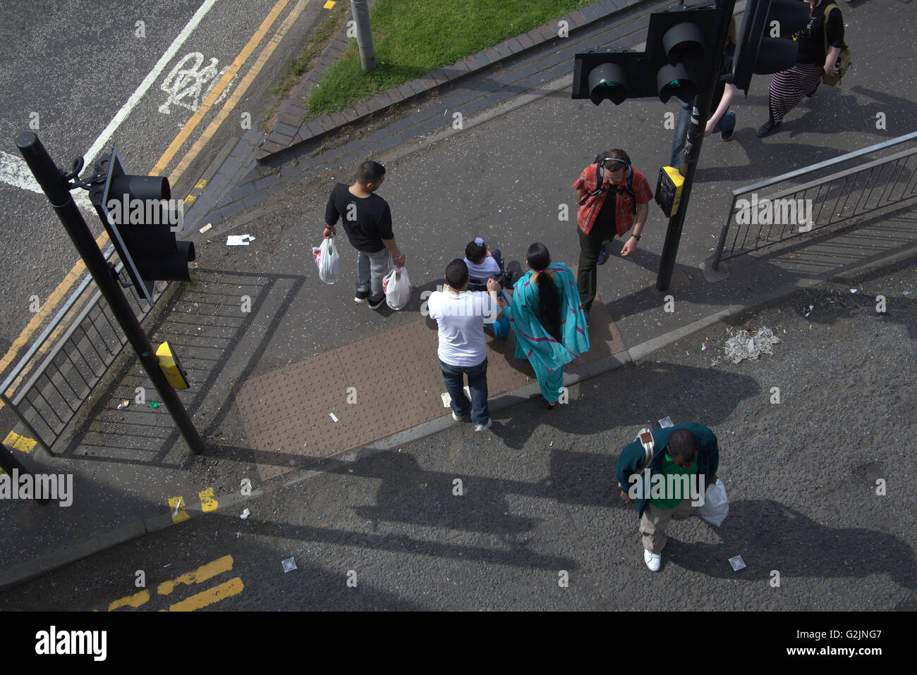 men and woman with Asian family crosses road from above at traffic lights, Glasgow, Scotland, UK. Stock Photo