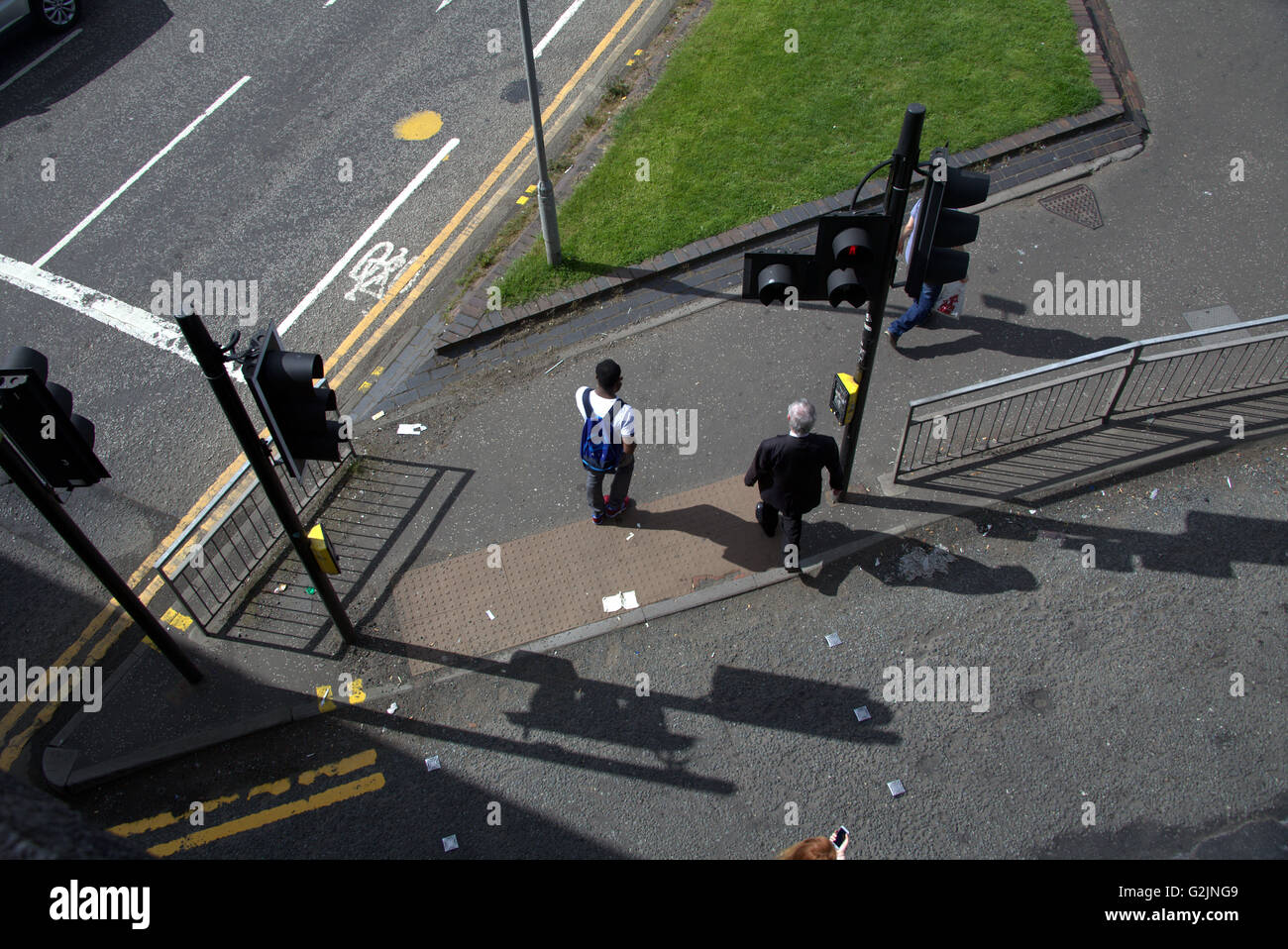 Schoolboy black with man  cross road from above at traffic lights, Glasgow, Scotland, UK. Stock Photo