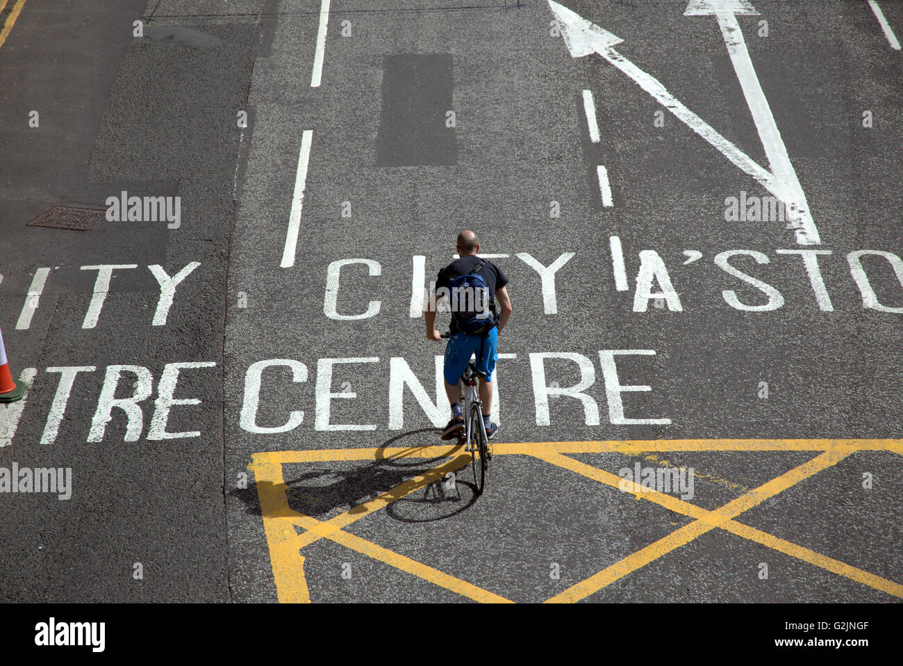 man on bicycle riding on road to city centre Glasgow, Scotland, UK. Stock Photo