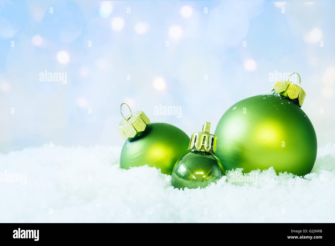 Three christmas balls on snow with soft bokeh background. Stock Photo