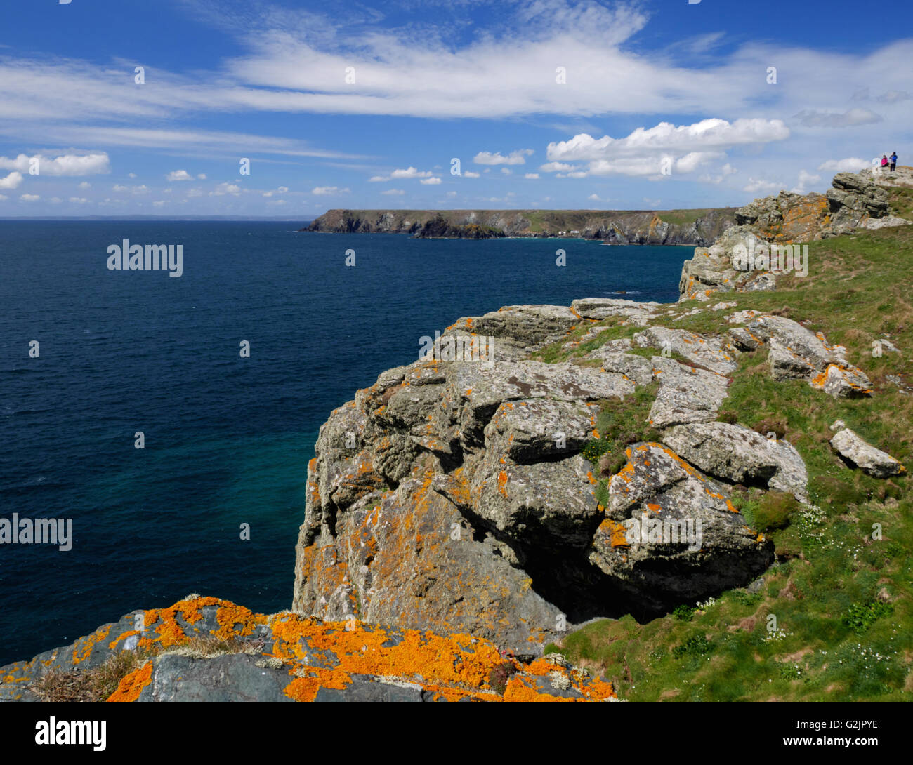 A rocky cliff with orange lichen covered rocks Stock Photo - Alamy