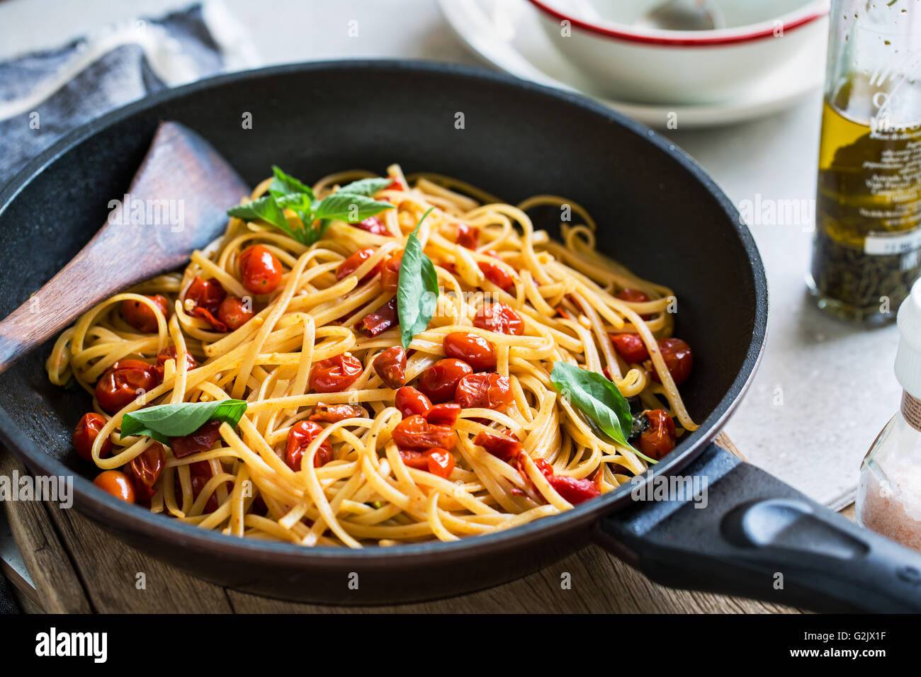 Freshly cooked  Fettuccine with cherry tomatoes in a sauce pan Stock Photo