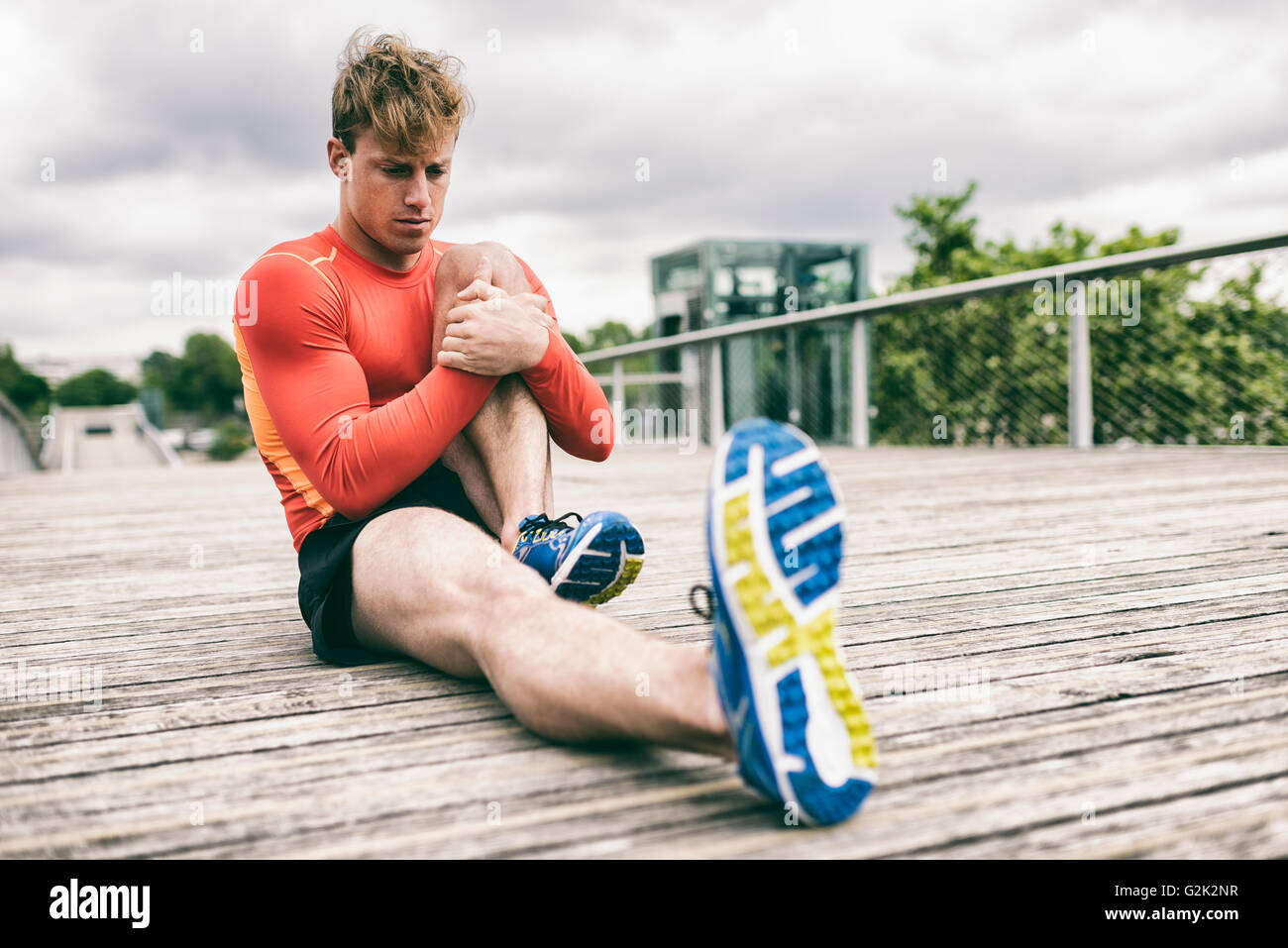 Sporty young man stretching muscles hi-res stock photography and images ...