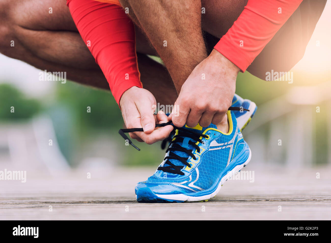 Runner tying his running shoes. City man shoelace sneakers Stock Photo