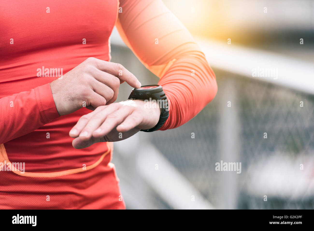 Running man looking sportwatch. Male runner jogging using smart watch outside Stock Photo