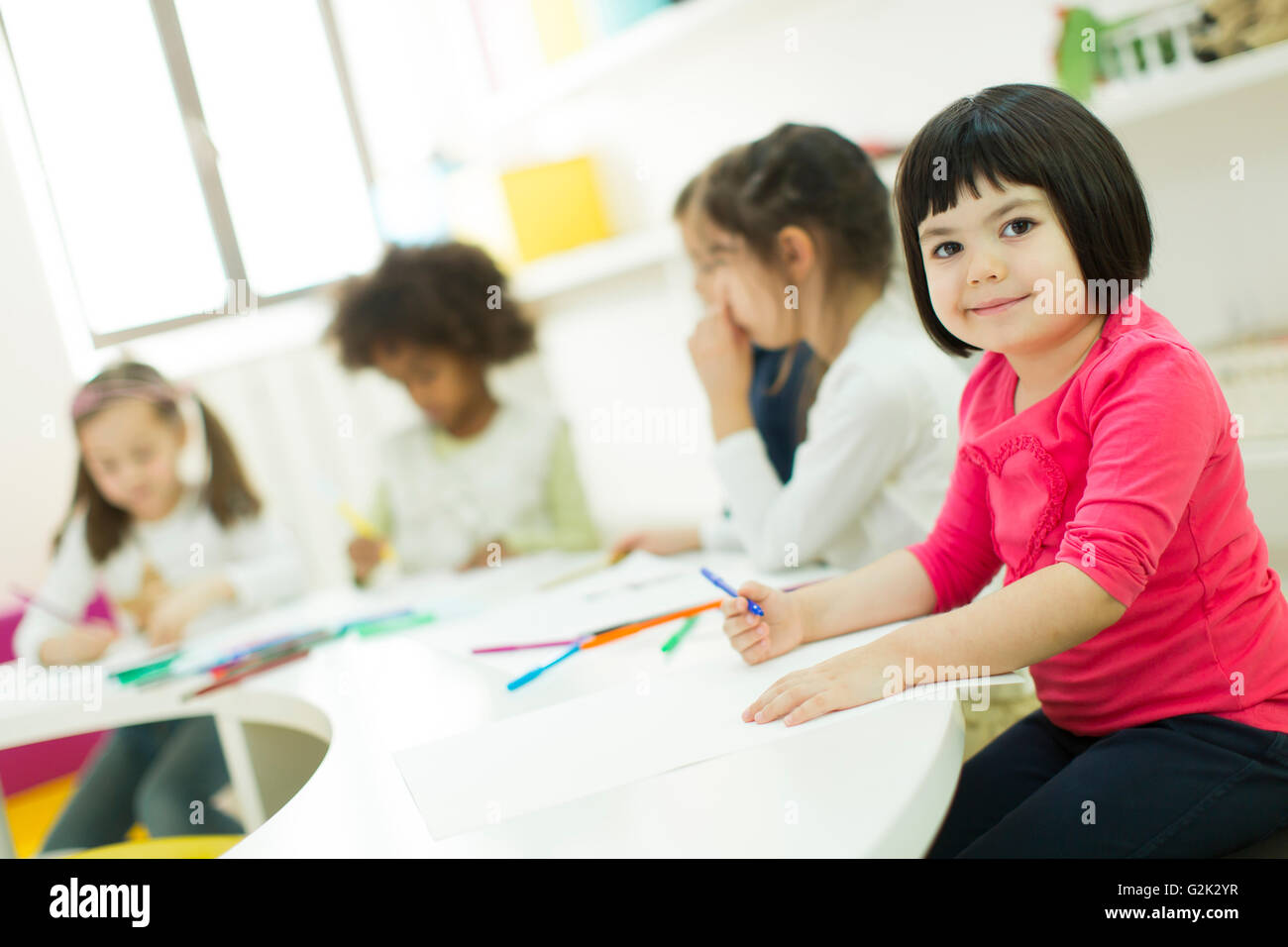 Little girls drawing and learning in the kindergarten Stock Photo