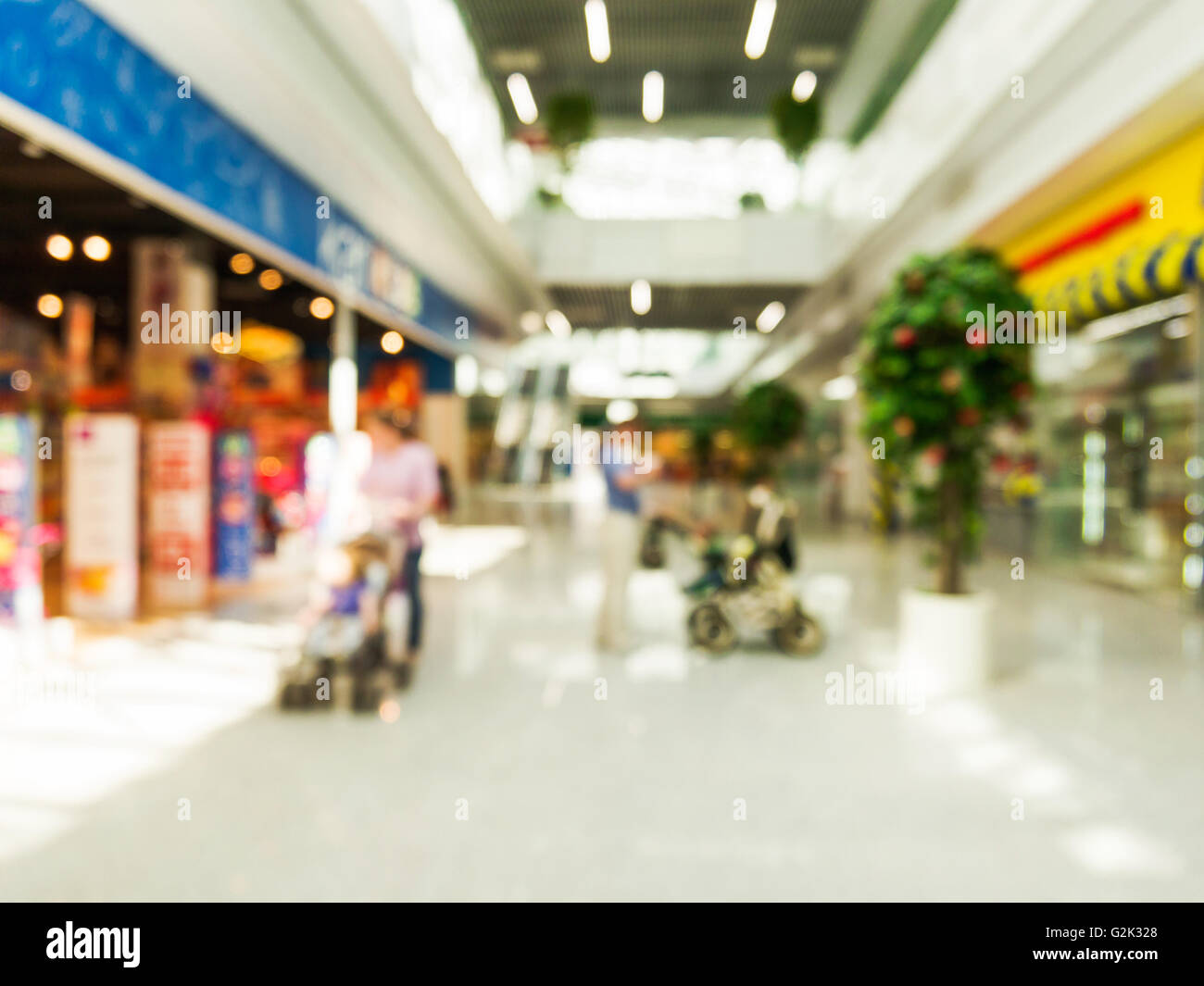Abstract background of shopping mall with unrecognizable persons with stroller, shallow depth of focus. Stock Photo