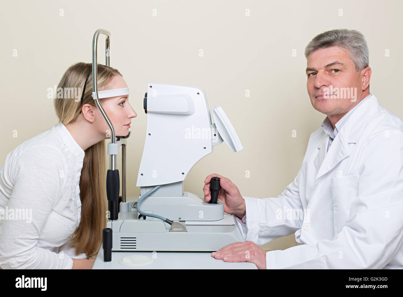 young woman having her eyes examined by an eye  elderly doctor. Stock Photo