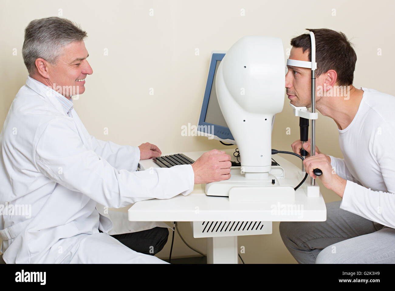 Man having his eyes examined by an eye elderly doctor. Stock Photo